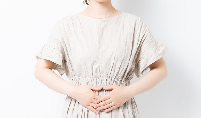 お腹に手をあてる女性