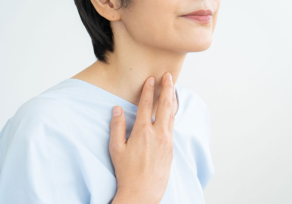 喉を抑える女性